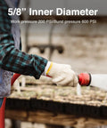 Side view of red rubber garden hose with a spray nozzle used outdoors by a gloved hand.