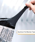 Top Shelf Aluminum Foil Bitumen Tape Real Heavy Duty Roof Leak Blocker Waterproof Butyl Rubber Flashing Roll Self Sealing Polymer Underlayment For Every Surface With No Sweat Weather Shielding being pulled by hand.
