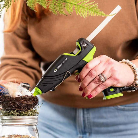 Person using a Surebonder glue gun with All Purpose 10 Inch Hot Glue Sticks For Crafts And DIY All Temperature Clear 5 Pound Box.