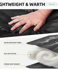 Hand touching black Lightweight Warm Weather Sleeping Bag For Adults And Teens with close-up of water-resistant fabric details.
