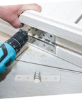 Stainless steel heavy-duty cabinet hinge with mounting plate being installed on white wooden cabinet.