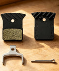 Road Bike Disc Brake Pads Kit With Spring And Pin For Consistent Stopping On Road Rides Resin And Metal Construction With Stainless Steel Support Durable Spares For Daily Rides And Routine Maintenance, shown with pads and pin