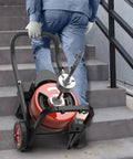 Person carrying Rugged Auto Feed Drain Auger 75 Ft 3/8 Inch Steel Core Cable Electric Sewer Snake up the stairs.