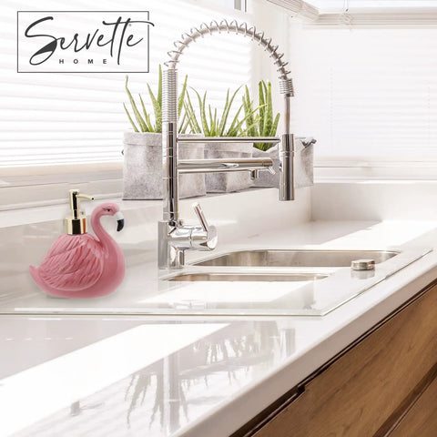 Pink Ceramic Soap Dispenser With Gold Pump For Bathroom Or Kitchen Sink, flamingo design next to chrome faucet on white countertop