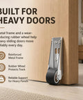 Heavy Duty Vertical Track Roller Wheel Built To Roll Smooth On Any Sliding Door Or Gate Featuring Whisper Quiet Rubber Bearing Casters and Universal Bottom Guide For No Fuss Home Upgrades, close-up view of roller against wood.