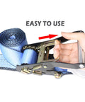 Hand using Heavy Duty Snap Hook Ratchet Straps 2 Inch By 114 Inch Axle Tie Down Set in blue with easy-to-use design