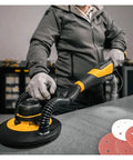Person using a sander with Forty Pcs 9 Inch Hook Loop Sandpaper Discs with 225mm holes on a work surface.