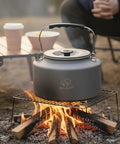 Two Point Two Liter Camping Kettle For Open Flame And Stove Fast Boil Water On The Go Lightweight Tea Pot in use over campfire.