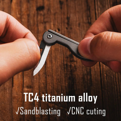 Mini Titanium Pocket Knife For Everyday Carry With Razor Sharp Folding Blade shown between fingers, TC4 titanium.