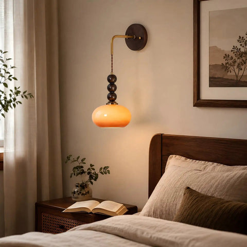Flyrose Set of 2 Vintage Caramel Glass Wall Sconces Mid Century Modern Lamp hanging above a bedside table with a book.