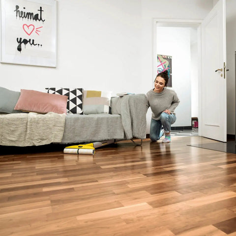 Woman using Cordless Hard Floor Cleaner With Mop Function FC 3 for wood laminate tile vinyl and stone floors in a living room.
