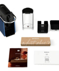 Pixie Espresso Machine By DeLonghi In Dark Blue with accessories shown, ideal for quick espresso and lungo brewing.