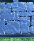 DIY Flagstone Concrete Mold Set 5-Piece Cobblestone Paver Molds on grass, durable ABS plastic, for garden path creation.