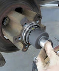 Mechanic using Ford 4 Lug Rear Axle Nut Socket Wrench For F Series Trucks Ten And A Half Inch Spindle Nut Size Two And Three Quarter Inch