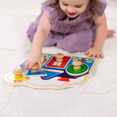 Child playing with First Shapes Jumbo Knob Puzzle For Toddlers With Wooden Peg Pieces, colorful shape matching toy on carpet