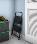 Lightweight Two Step Home Stool For Easy Reaching And Cleaning With Non Marring Feet in folded position, compact design next to storage boxes.