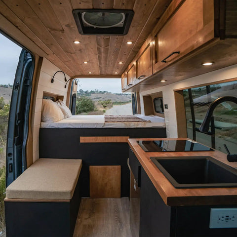 Interior of a camper van with wooden accents, showcasing the Ultra Slim 12V Led Ceiling Puck Light with Sweet Dimming Controls.