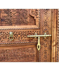 Close-up of hand carved solid wood barn door with intricate patterns and brass locker, rustic antique style.