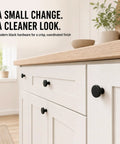 Rock Solid Matte Black Cabinet Knobs 20 Pack Round Zinc Alloy Drawer Handles Single Hole Mount Snug Threaded Grip Heavy Duty Kitchen Cupboard Pulls Perfect Room Refresh, close-up on modern black knobs on white cabinet.