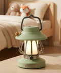 Rechargeable Kid Friendly Lantern Night Light With Dimmable 3 Color LEDs on a table near a bed with toys in background.