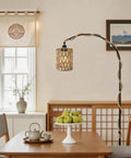 Amp Up Your Space With This Straight Up Badass Boho Pendant Light Featuring A Heavy Duty 16.5 Ft Plug In Swag Cord And Handwoven Rattan Cylinder Shade For Zero Hassle Setup And Chill Room Vibes. Woven rattan shade hanging over a dining table with decorative fruit.