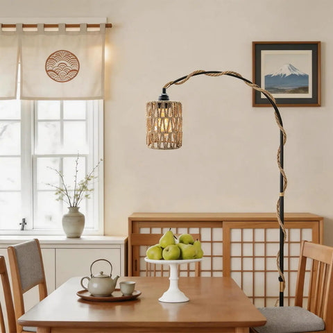 Amp Up Your Space With This Straight Up Badass Boho Pendant Light Featuring A Heavy Duty 16.5 Ft Plug In Swag Cord And Handwoven Rattan Cylinder Shade For Zero Hassle Setup And Chill Room Vibes. Woven rattan shade hanging over a dining table with decorative fruit.
