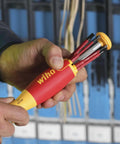 Person holding Insulated SlimLine Ultra Driver Blade Set with Slotted and Phillips Bits, 7 Piece Kit, in front of panel wiring.