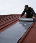 Man applying Ridiculously Durable Peel And Stick Waterproof Roofing Roll 39 X 32 Foot self adhesive membrane on metal roof.