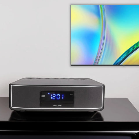 Exos Home Speaker With 30W RMS Power, Bluetooth Streaming, CD Player, and FM Radio on a shelf below a colorful wall art piece.
