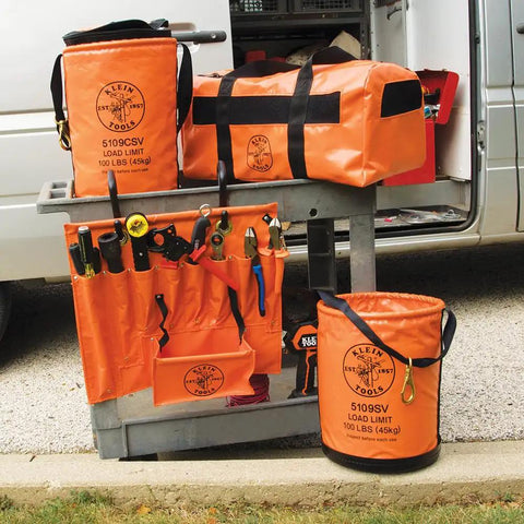 Bright Orange Vinyl Tool Bucket With Swivel Snap And Web Handle 12 Inch Diameter 100 Pound Load Rating Water Resistant Lineman Bucket For Electricians Who Hustle Durable Carry Handle Keeps Tools Secure And Easy To Grab with matching tool bags displayed on a cart.