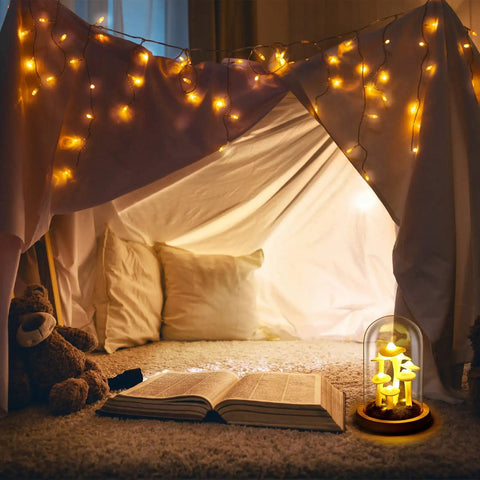 Mushroom Night Light In Glass Dome LED Decor With Wooden Base for home decor placed in a cozy reading nook with string lights.