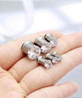 Hand holding ASTM F136 Titanium 0G Round CZ Ear Gauges Tunnels Screw Fit Flesh Plugs Gauges 8mm for body piercing jewelry.