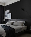 Stylish bedroom with dark wall, modern decor, and framed art above a bed.