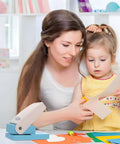 Mother and child using Portable Oval Tab Punch For Scrapbooking And Card Making with paper and craft supplies on a table.