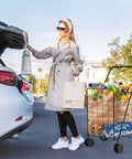 Woman with Jumbo Folding Shopping Cart On Swivel Wheels With Dual Basket, groceries packed, easy fold design for quick storage