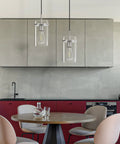 3 Pack Clear Glass Vintage Pendant Lights With Brushed Nickel Finish For Kitchen Island above a modern dining table.