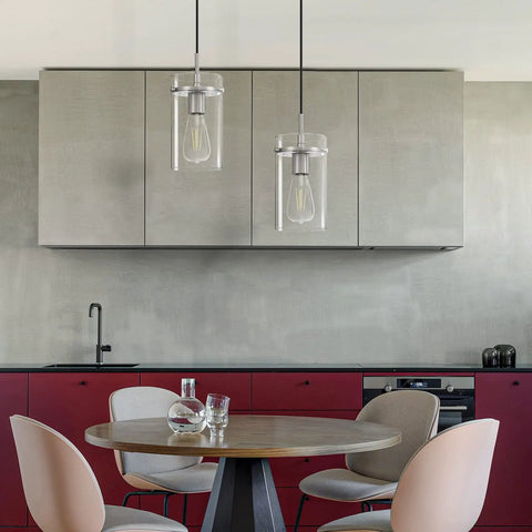 3 Pack Clear Glass Vintage Pendant Lights With Brushed Nickel Finish For Kitchen Island above a modern dining table.