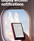 Next Level Kindle Paperwhite E Reader With 16 GB Storage Built Different For Marathon Reading Featuring A Crisp Seven Inch Glare Free Display With Buttery Smooth Page Turns And Insane Weekly Battery Life In Sleek Black, held near an airplane window.