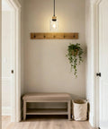 Matte Black Bathroom Pendant Light Fixture with Clear Glass Shade hung in an entryway above a bench and plant
