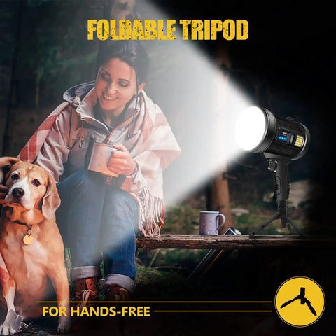 Woman with dog uses Beast 1 Million Lumens Spotlight With Solar Charging on tripod outdoors at night.