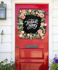 Red front door with 'Welcome Home' sign surrounded by floral wreath