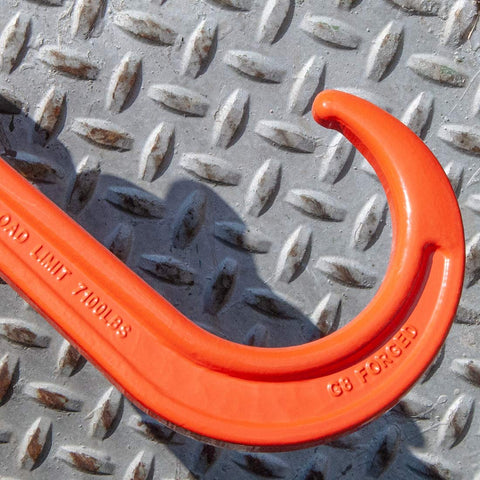 Close-up of red G8 forged hook from Alloy Tow Chain With Forged Long J Hook 3/8 Inch By 8 Foot Grade 80 Pro Series 7,100 Pound Safe Working Load Heavy Duty Tow Chain For Trucks Towing And Vehicle Recovery Ideal For Heavy Duty Towing On Flatbeds And Rural Roads on a textured metal surface.