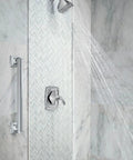 Stainless Steel 24-Inch Bathroom Grab Bar In Brushed Nickel For Safety, ADA Compliant, installed beside a shower in a bathroom.
