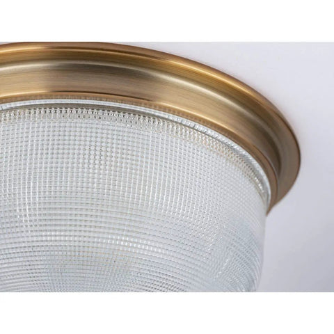 Close-up of vintage brass two light close to ceiling flush mount fixture in Archie collection style with prismatic glass