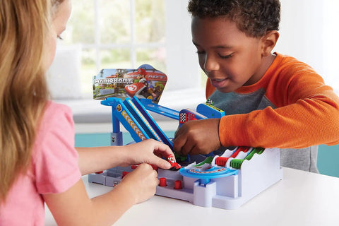 Children playing with Mario Kart Racing Deluxe Obstacle Course Set with dual lane track and lap counter on a table.