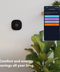 Wall-mounted smart thermostat with WiFi and voice control, shown alongside app screen for energy settings.