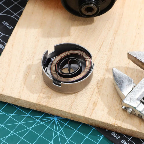 Drill Press Return Spring Set For Quill Coil Assembly with heavy-duty steel spring on a wooden bench, tool at side.