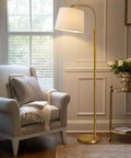 62 Inch Tall Arc Floor Lamp With Antique Brass Shade Lantern Industrial Gold Finish Mid Century Modern Reading Light next to armchair