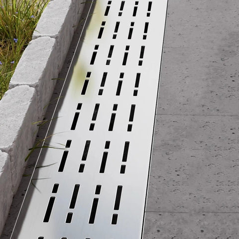 Pro Grade Trench Drain Kit With Removable Channel And Grates For Outdoor Yard Patio Deck Garden Lawn Pathway Drainage System Built To Last And Weatherproof Stainless Steel installed on a pathway next to grass and stone border.