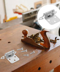 10 Pack Half Overlay Spring Cabinet Hinges, 1.2mm white nickel metal on workbench with screws, soft close feature